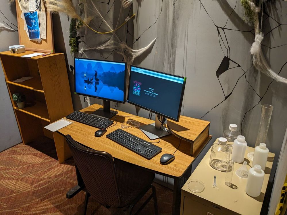 two computer screens, spooky decorations, and laboratory equipment inside the escape room