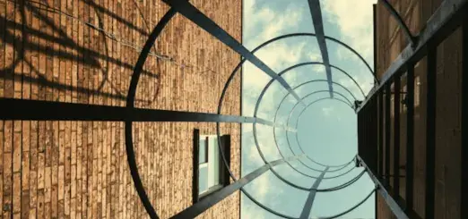 A photo looking up between brick buildings through a glass cylinder