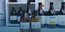 Image shows chemicals in brown bottles in a lab like setting.