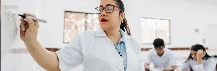 Woman at a white board in front of a class