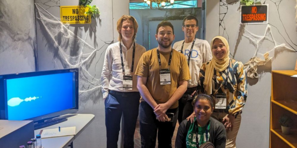 A group of students smiles after completing the Lab 217 escape room at the green chemistry and engineering conference